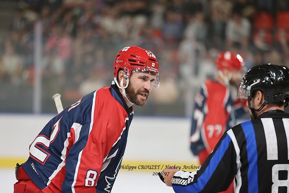 Joueur de hockey en rouge face à un arbitre