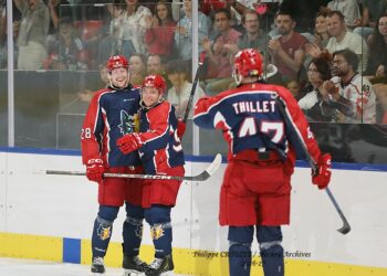 Joueurs de hockey célébrant devant des supporters enthousiastes