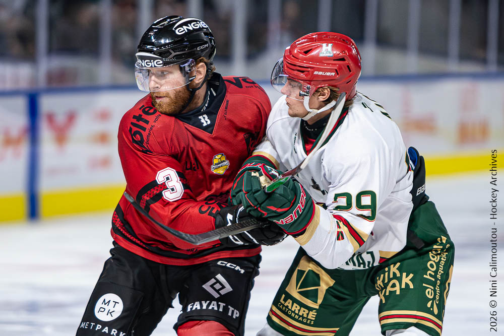 Deux hockeyeurs se disputent le palet sur la glace